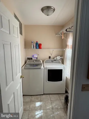 a utility room with cabinets washer and dryer