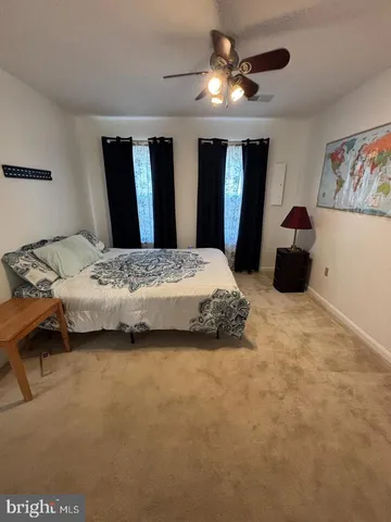 a bedroom with a bed ceiling fan and a window