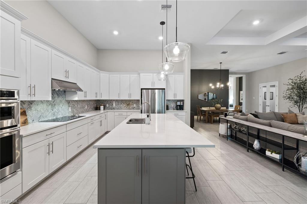 20734 Corkscrew Shores Boulevard Estero, FL 33928 - Photo 13 of 50 a large kitchen with stainless steel appliances kitchen island a large island in the center