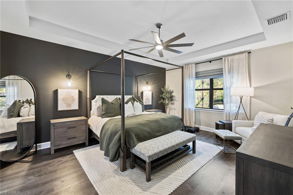 20734 Corkscrew Shores Boulevard Estero, FL 33928 - Photo 20 of 50 a spacious bedroom with a bed a chandelier and a window