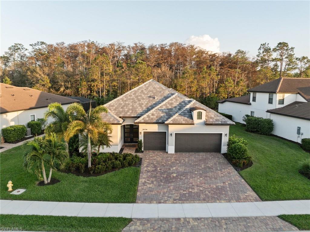 20734 Corkscrew Shores Boulevard Estero, FL 33928 - Photo 2 of 50 a front view of a house with a garden and trees