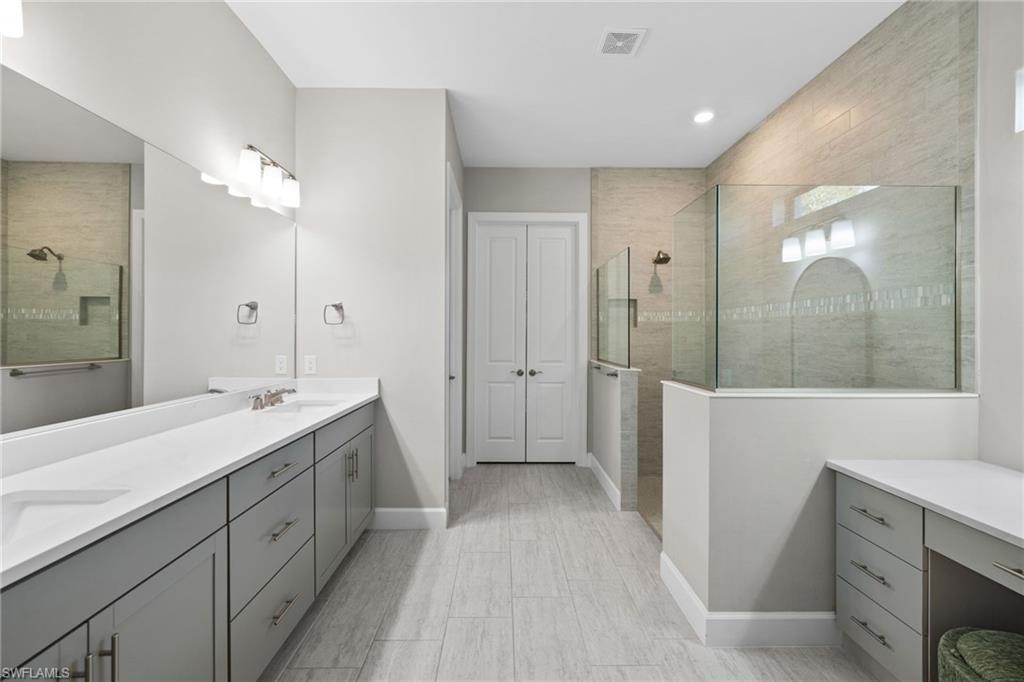 20734 Corkscrew Shores Boulevard Estero, FL 33928 - Photo 23 of 50 a spacious bathroom with a double vanity sink a large mirror and shower