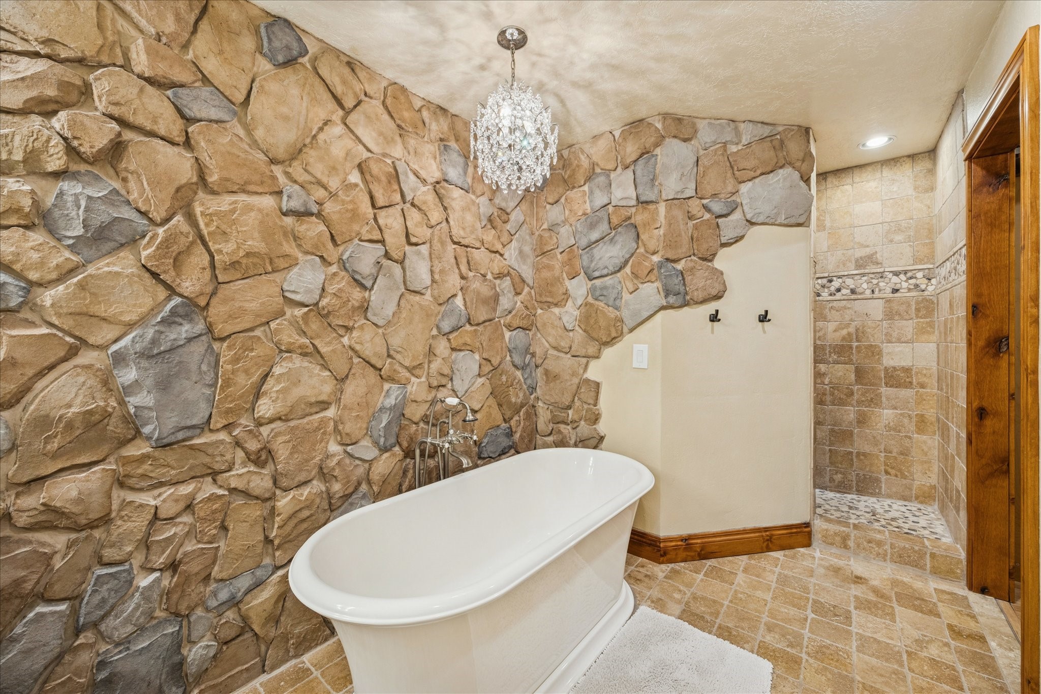 640 Piney Creek Road Bellville, TX 77418 - Photo 14 of 31 The primary bath offers a soaking tub accented by a charming chandelier and a spacious walk-in shower with two shower heads.