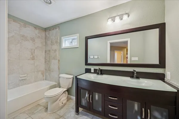 a bathroom with a granite countertop double vanity sink and a mirror