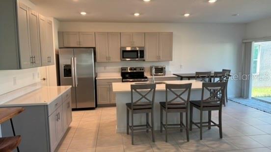 4520 Ranunculus Street Haines City, FL 33844 - Photo 4 of 19 a kitchen with stainless steel appliances a table chairs refrigerator and microwave
