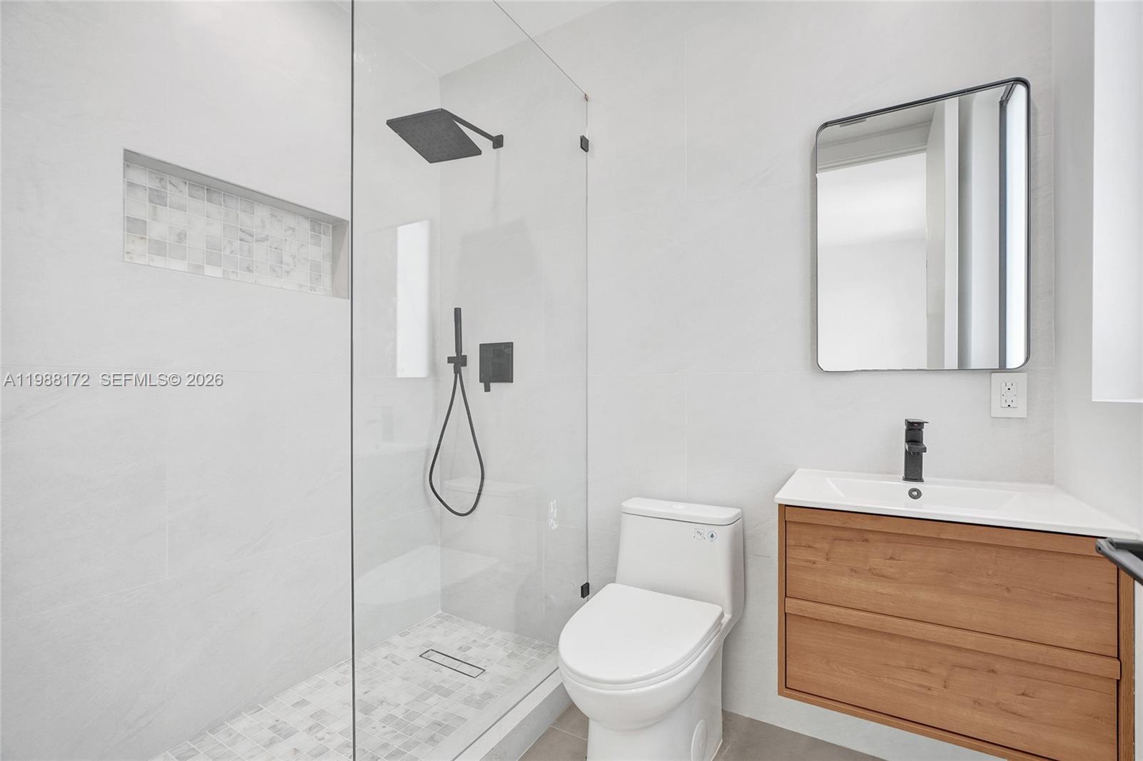 2421 Southwest 16th Terrace Miami, FL 33145 - Photo 23 of 37 a bathroom with a toilet sink vanity and mirror