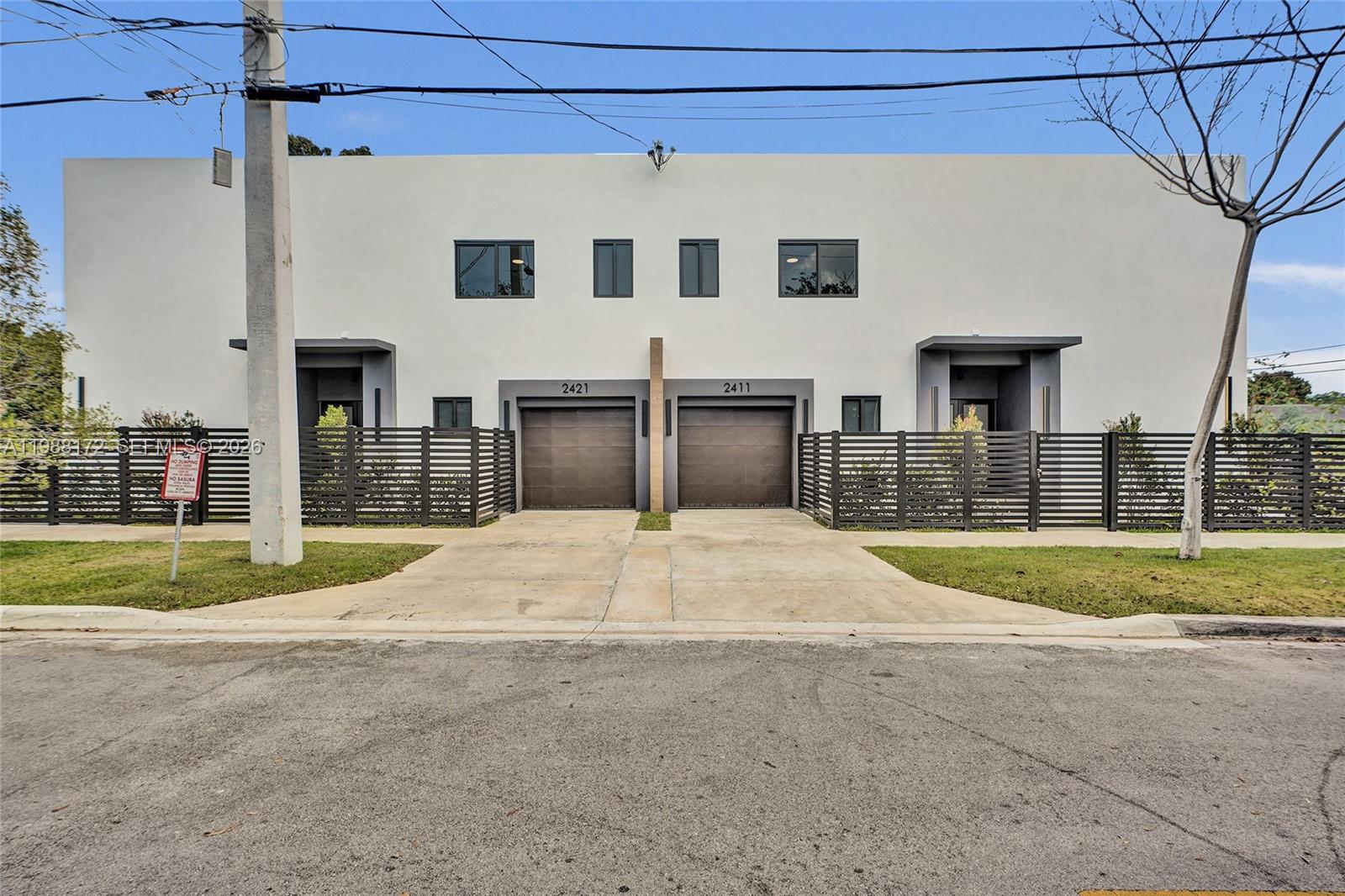 2421 Southwest 16th Terrace Miami, FL 33145 - Photo 36 of 37 a front view of a house with a yard and garage