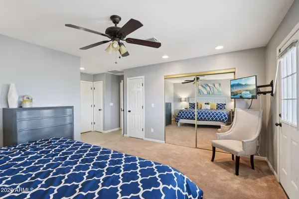 a bedroom with a bed chairs and a window