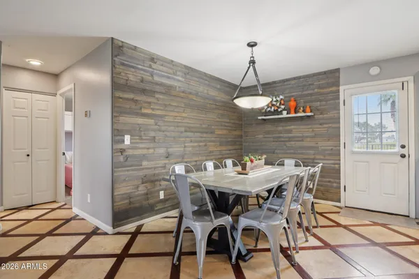 a kitchen with stainless steel appliances granite countertop a stove a refrigerator a kitchen island a dining table and chairs with the wooden floor