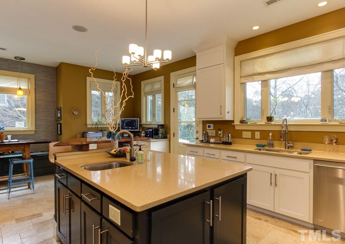 2711 Barmettler Street Raleigh, NC 27607 - Photo 11 of 25 a kitchen with center island a sink appliances and cabinets