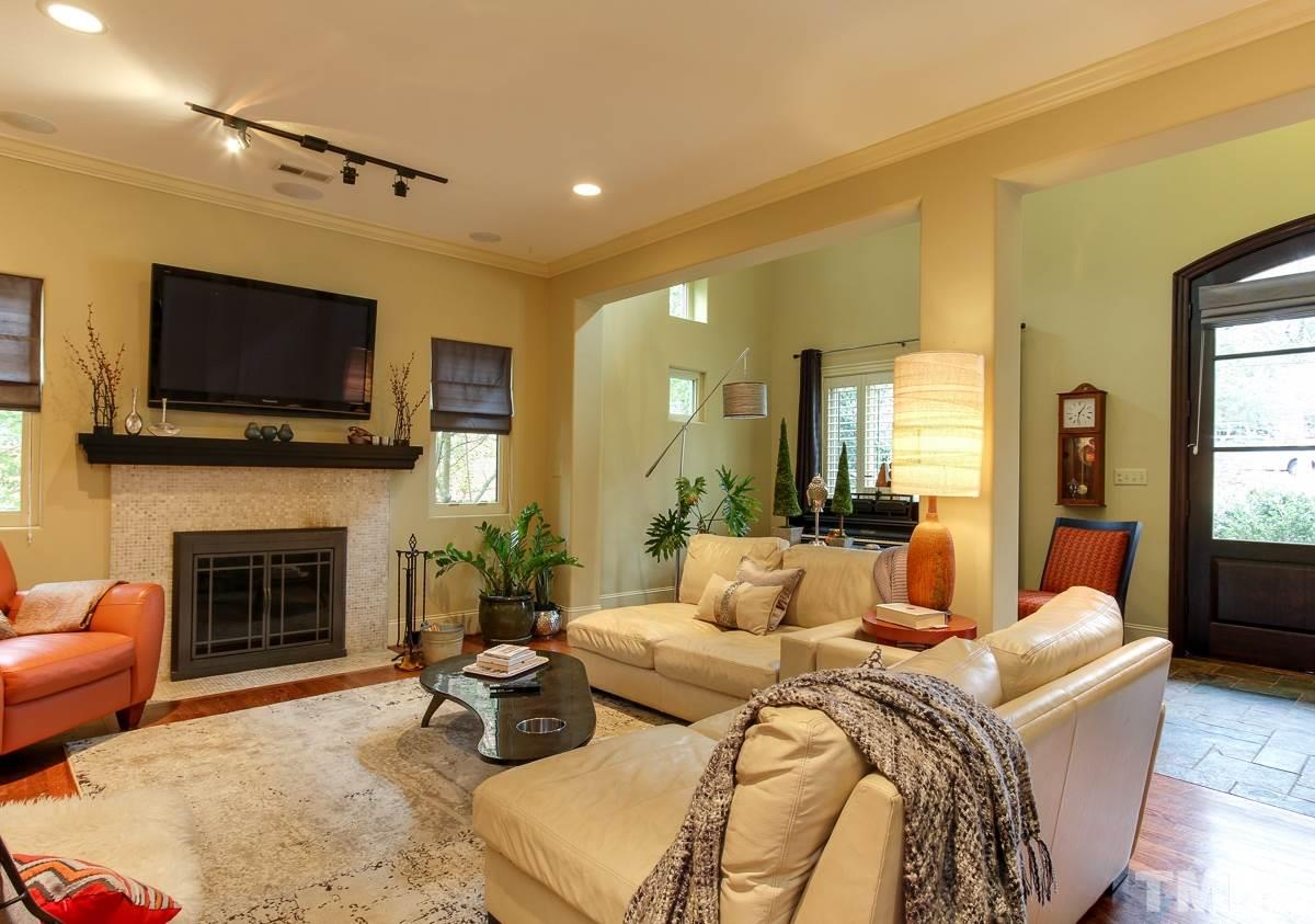 2711 Barmettler Street Raleigh, NC 27607 - Photo 4 of 25 a living room with fireplace furniture and a flat screen tv
