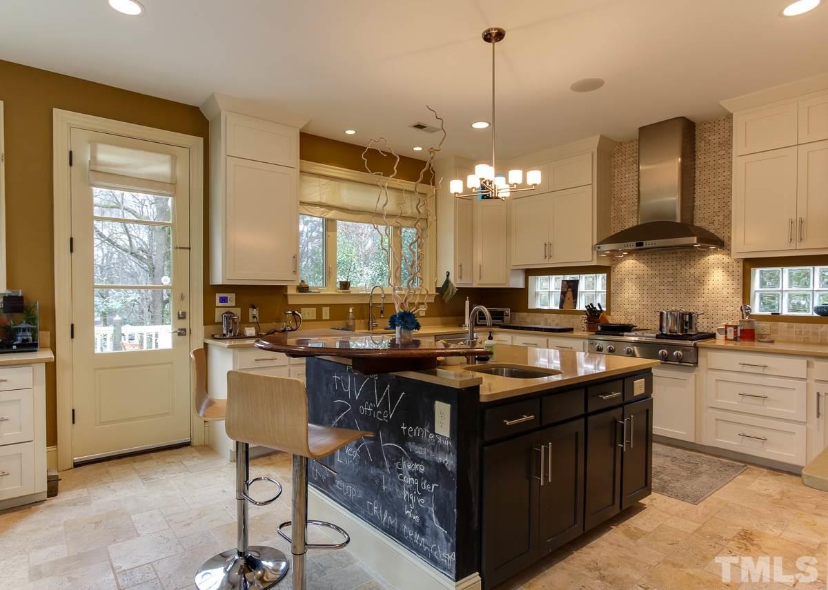2711 Barmettler Street Raleigh, NC 27607 - Photo 7 of 25 a kitchen with a stove a sink a center island and cabinets