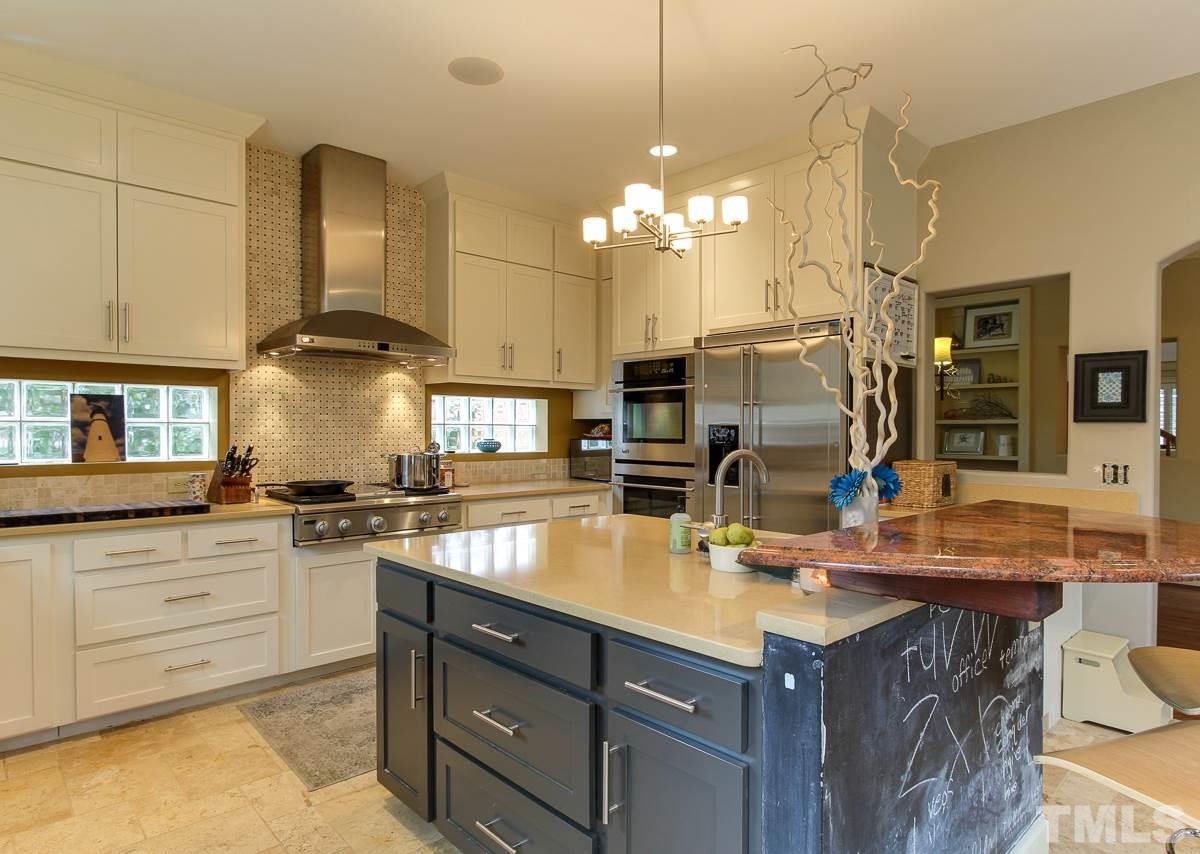 2711 Barmettler Street Raleigh, NC 27607 - Photo 8 of 25 a kitchen with stainless steel appliances granite countertop a sink a stove and a wooden cabinets