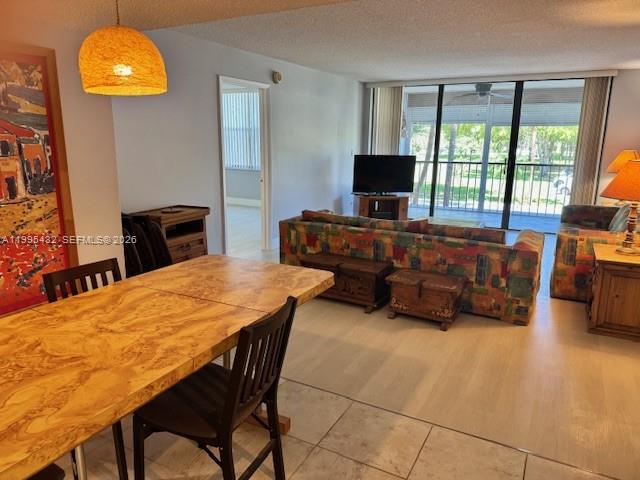 16300 Golf Club Road, Unit 208 Weston, FL 33326 - Photo 4 of 24 a living room with furniture a flat screen tv and a large window