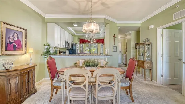 a view of a dining room with furniture a chandelier and window