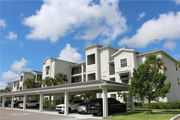 a front view of a building with street view and trees