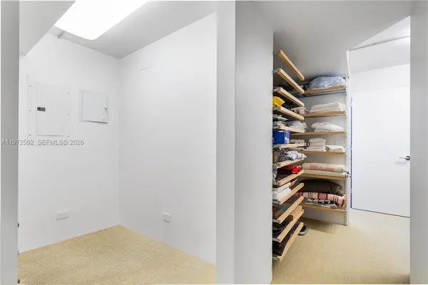 a view of walk in closet with clothes and shoes