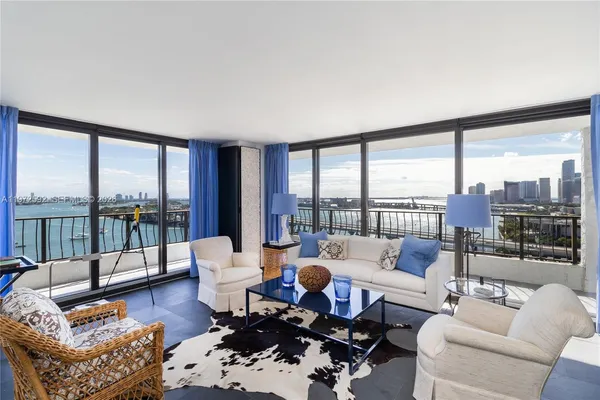 a living room with furniture and floor to ceiling windows