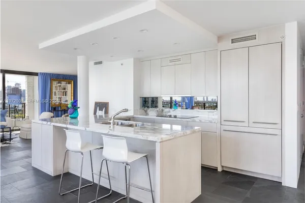 a kitchen with kitchen island granite countertop a sink cabinets and wooden floor