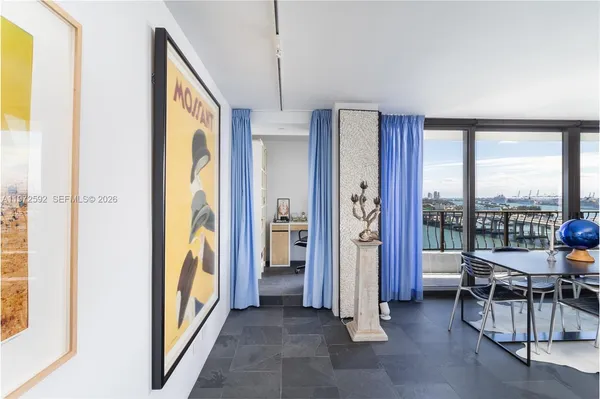 a view of a livingroom with furniture and floor to ceiling window