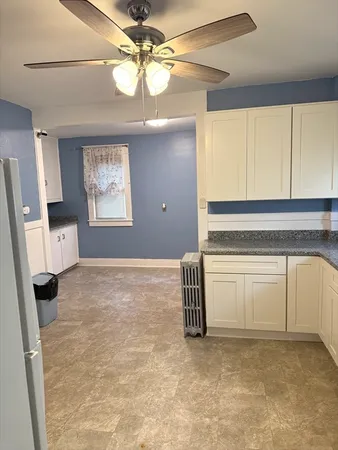 a view of an empty room with window and cabinet