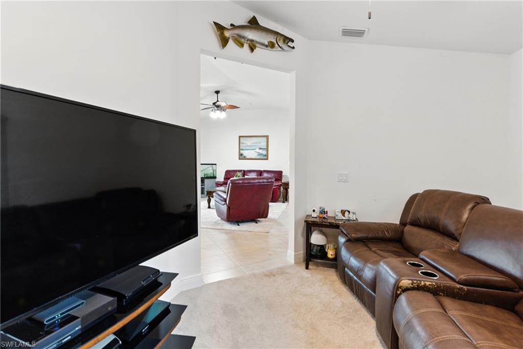 176 Venus Cay Naples, FL 34114 - Photo 12 of 50 Living room with light colored carpet, light tile patterned flooring, and ceiling fan