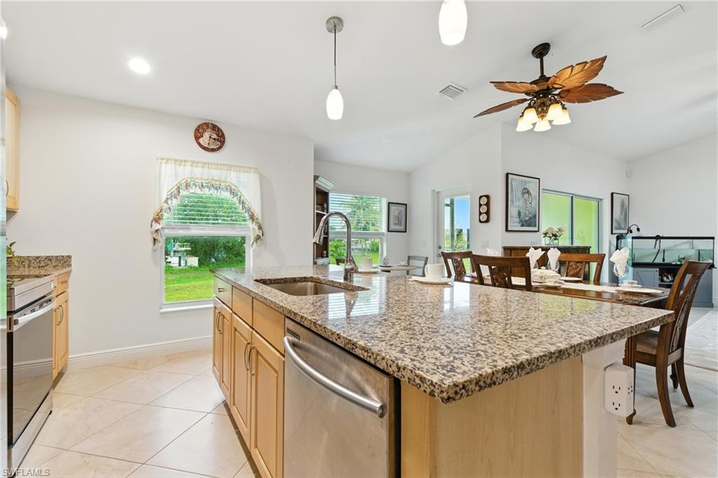 176 Venus Cay Naples, FL 34114 - Photo 19 of 50 Kitchen featuring light stone countertops, appliances with stainless steel finishes, light brown cabinets, hanging light fixtures, and recessed lighting