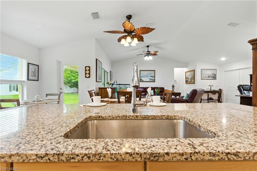 176 Venus Cay Naples, FL 34114 - Photo 50 of 50 Kitchen with open floor plan, light stone counters, and vaulted ceiling