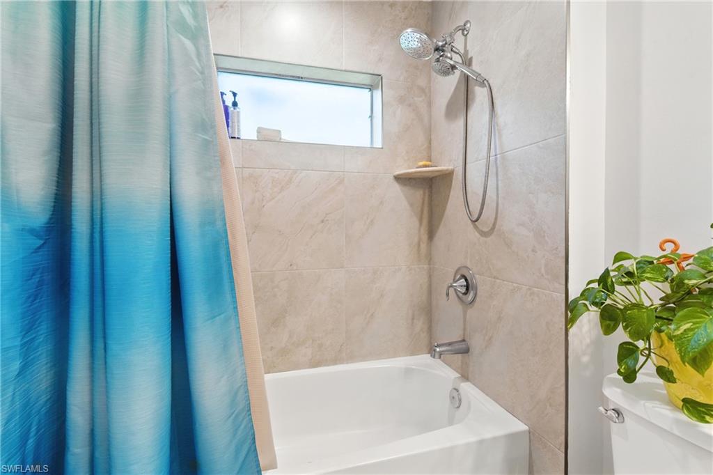 176 Venus Cay Naples, FL 34114 - Photo 23 of 50 Bathroom featuring shower / bathtub combination with curtain and toilet