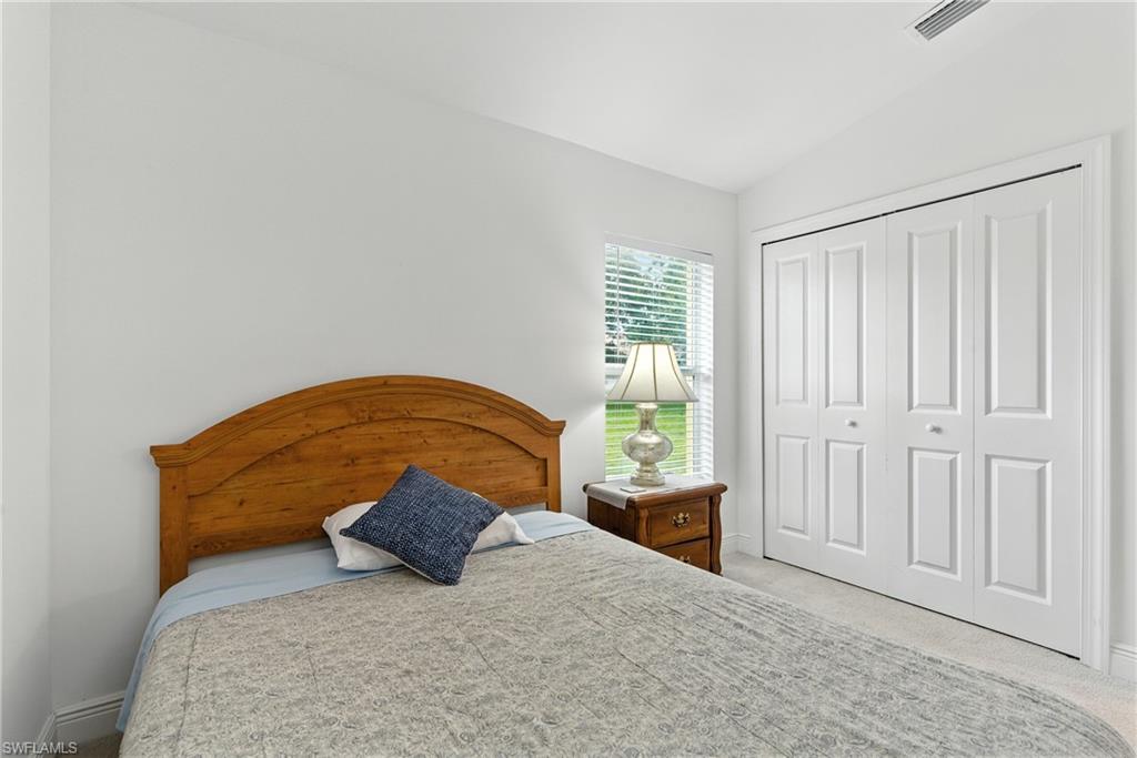 176 Venus Cay Naples, FL 34114 - Photo 29 of 50 Bedroom featuring light carpet, a closet, and vaulted ceiling