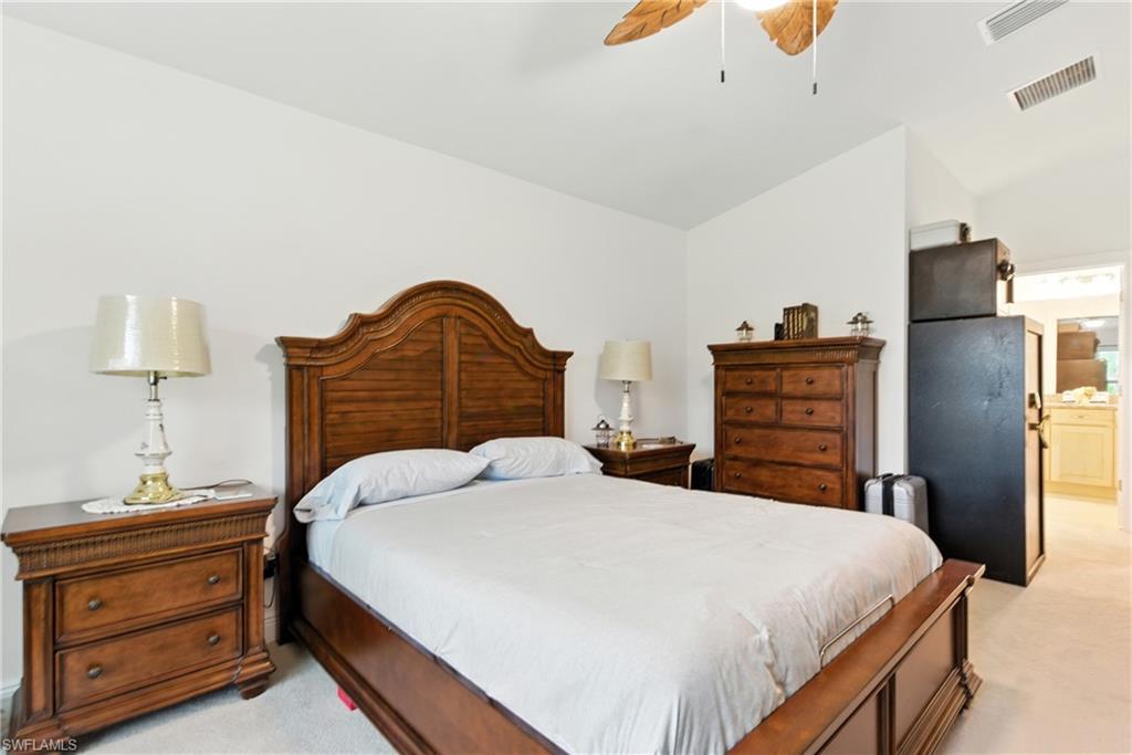 176 Venus Cay Naples, FL 34114 - Photo 33 of 50 Bedroom featuring light colored carpet, ensuite bath, ceiling fan, and lofted ceiling