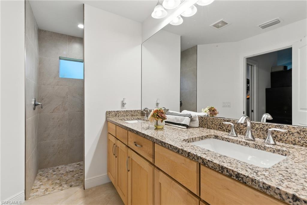 176 Venus Cay Naples, FL 34114 - Photo 37 of 50 Bathroom featuring double vanity, a walk in shower, and light tile patterned flooring