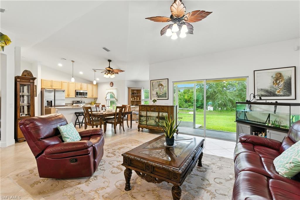 176 Venus Cay Naples, FL 34114 - Photo 10 of 50 Living room featuring a ceiling fan, high vaulted ceiling, and light tile patterned floors
