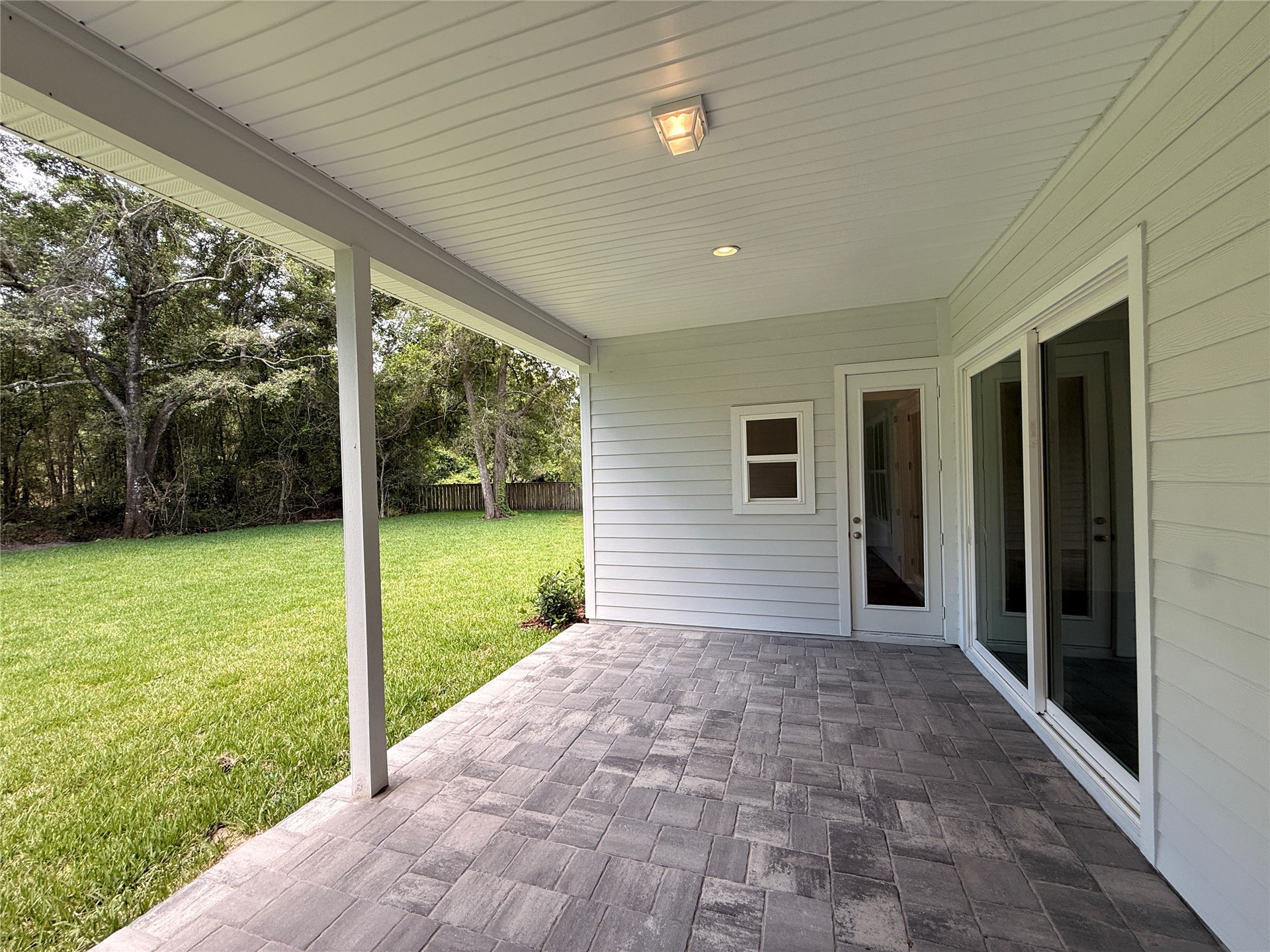 96130 Captains Pointe Road Yulee, FL 32097 - Photo 25 of 32 a view of a porch with a big yard potted plants and floor to ceiling window