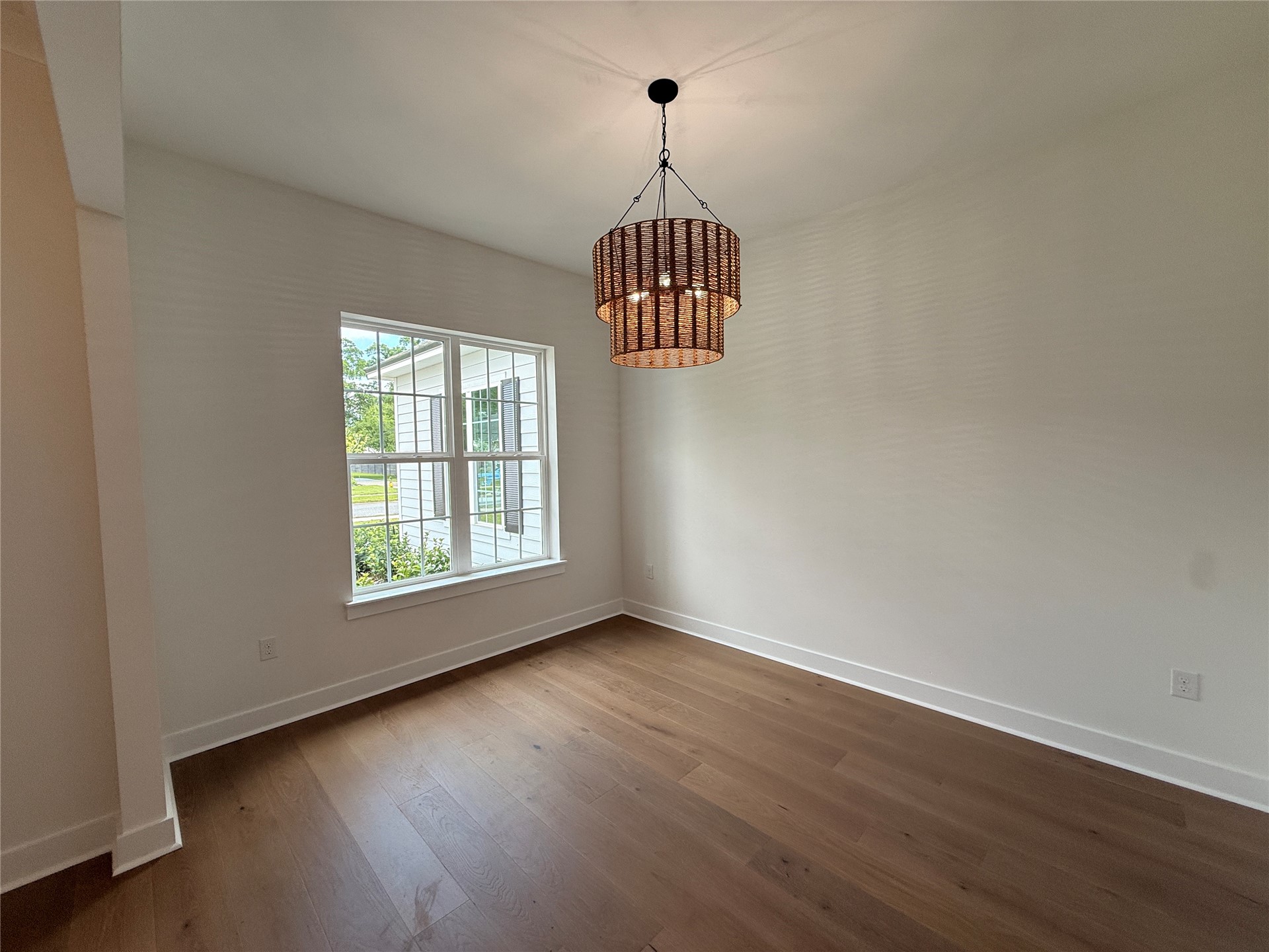 96130 Captains Pointe Road Yulee, FL 32097 - Photo 8 of 32 an empty room with wooden floor chandelier and windows