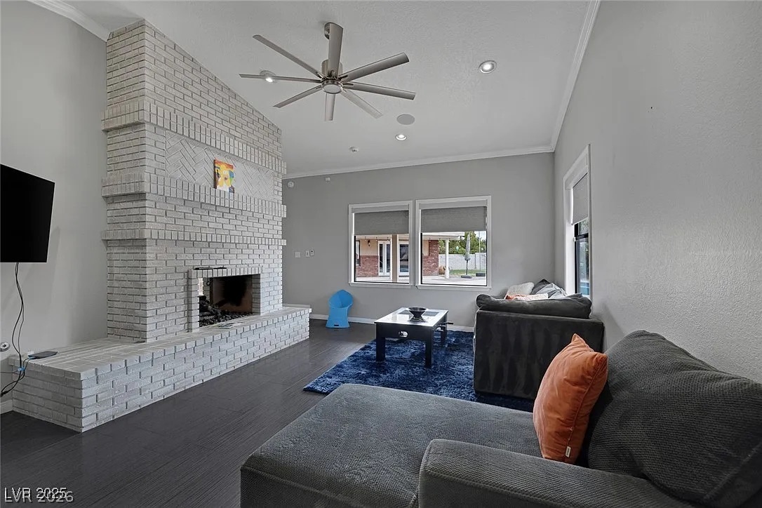 9 Quail Run Road Henderson, NV 89014 - Photo 34 of 57 An inviting living room features a striking brick fireplace and durable dark wood flooring.