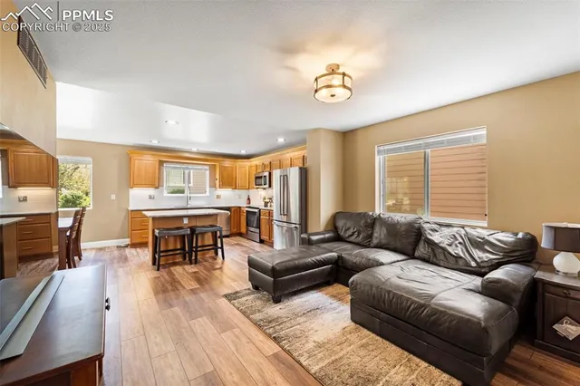 a living room with furniture kitchen view and a large window