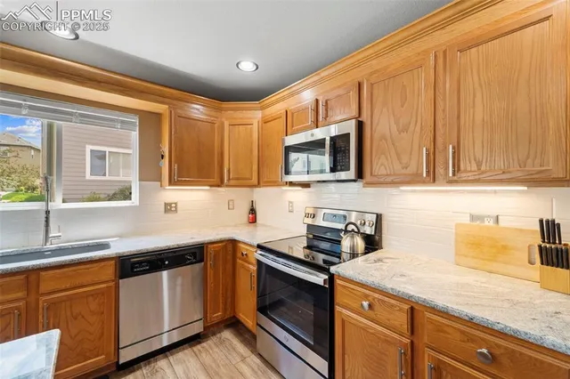 a kitchen with stainless steel appliances granite countertop a sink stove and microwave