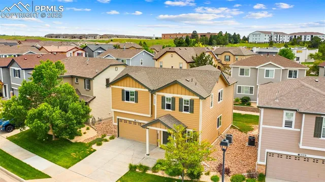 an aerial view of residential houses with outdoor space and ocean view