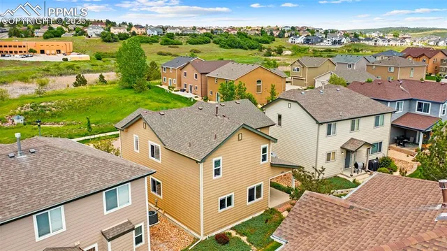 an aerial view of multiple houses with a yard