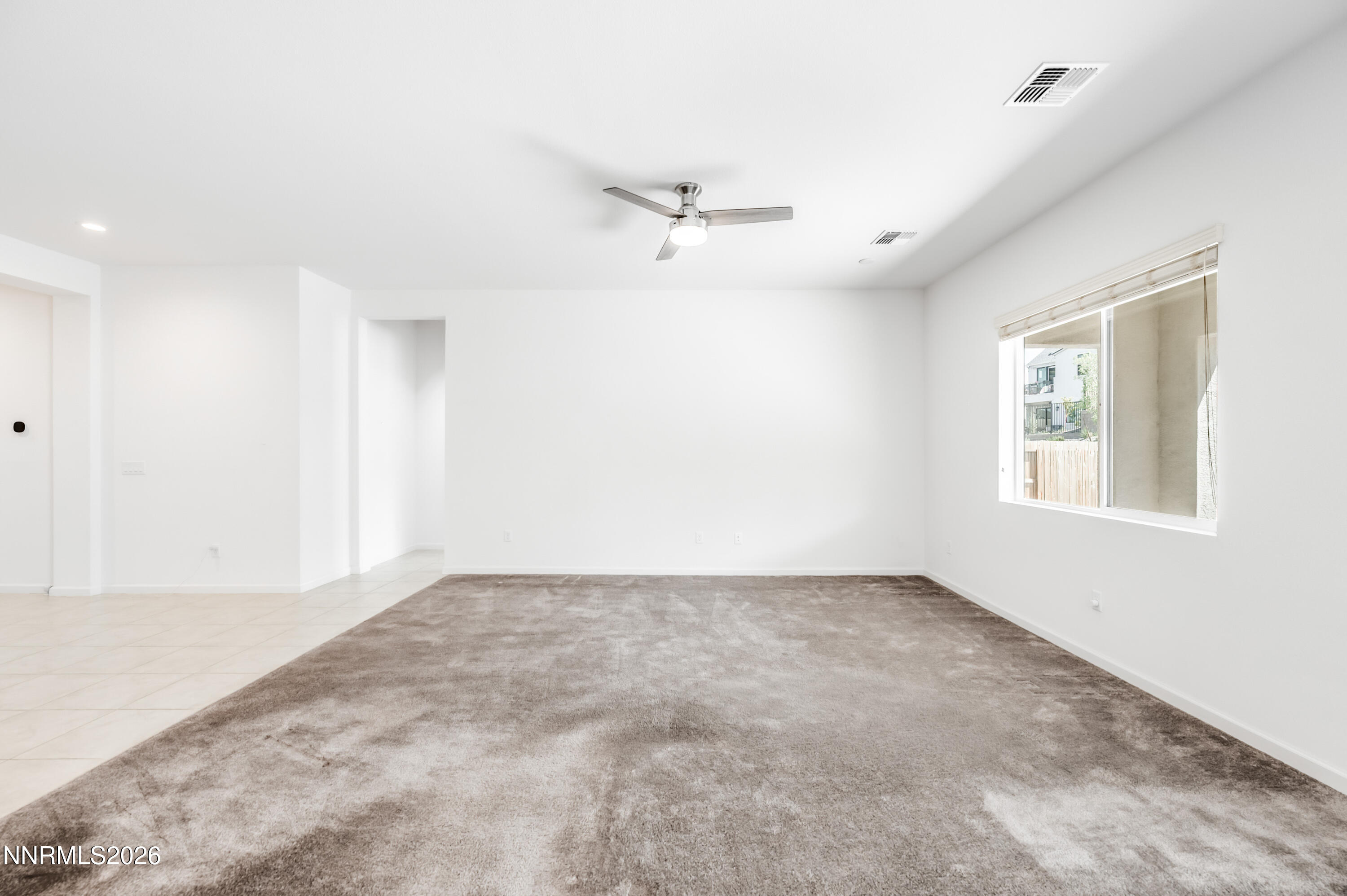 15024 Emerald Sunset Lane Reno, NV 89521 - Photo 19 of 73 an empty room with a window and a ceiling fan
