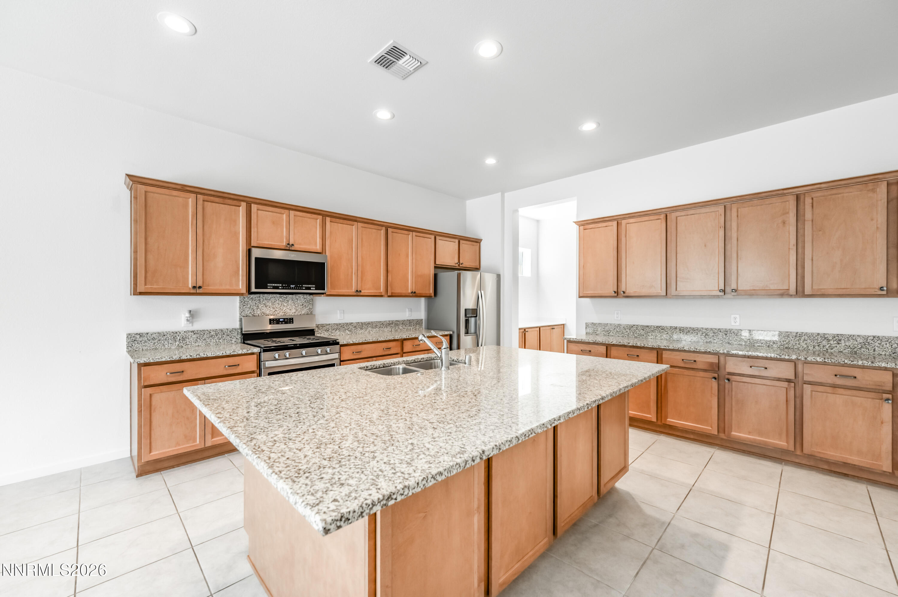 15024 Emerald Sunset Lane Reno, NV 89521 - Photo 25 of 73 a kitchen with stainless steel appliances granite countertop a sink counter space cabinets and a large window