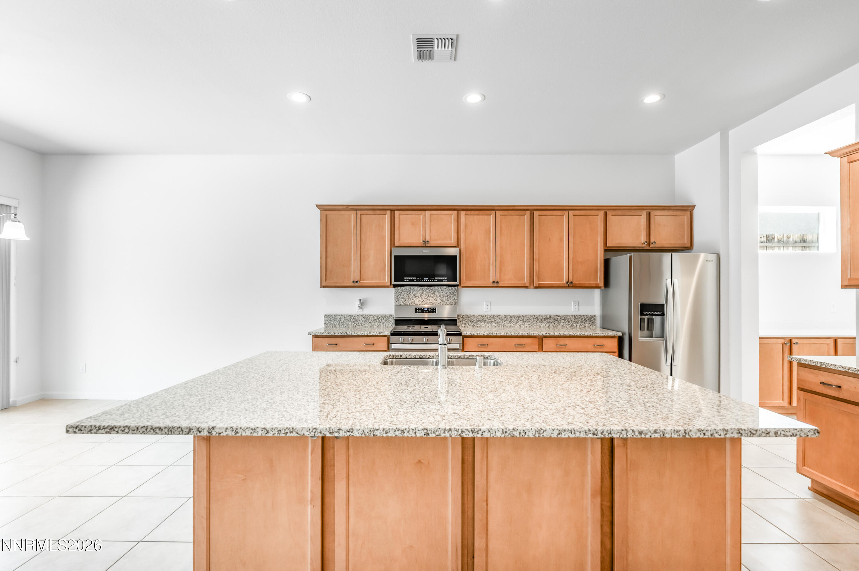 15024 Emerald Sunset Lane Reno, NV 89521 - Photo 26 of 73 a kitchen with granite countertop a sink a stove and refrigerator