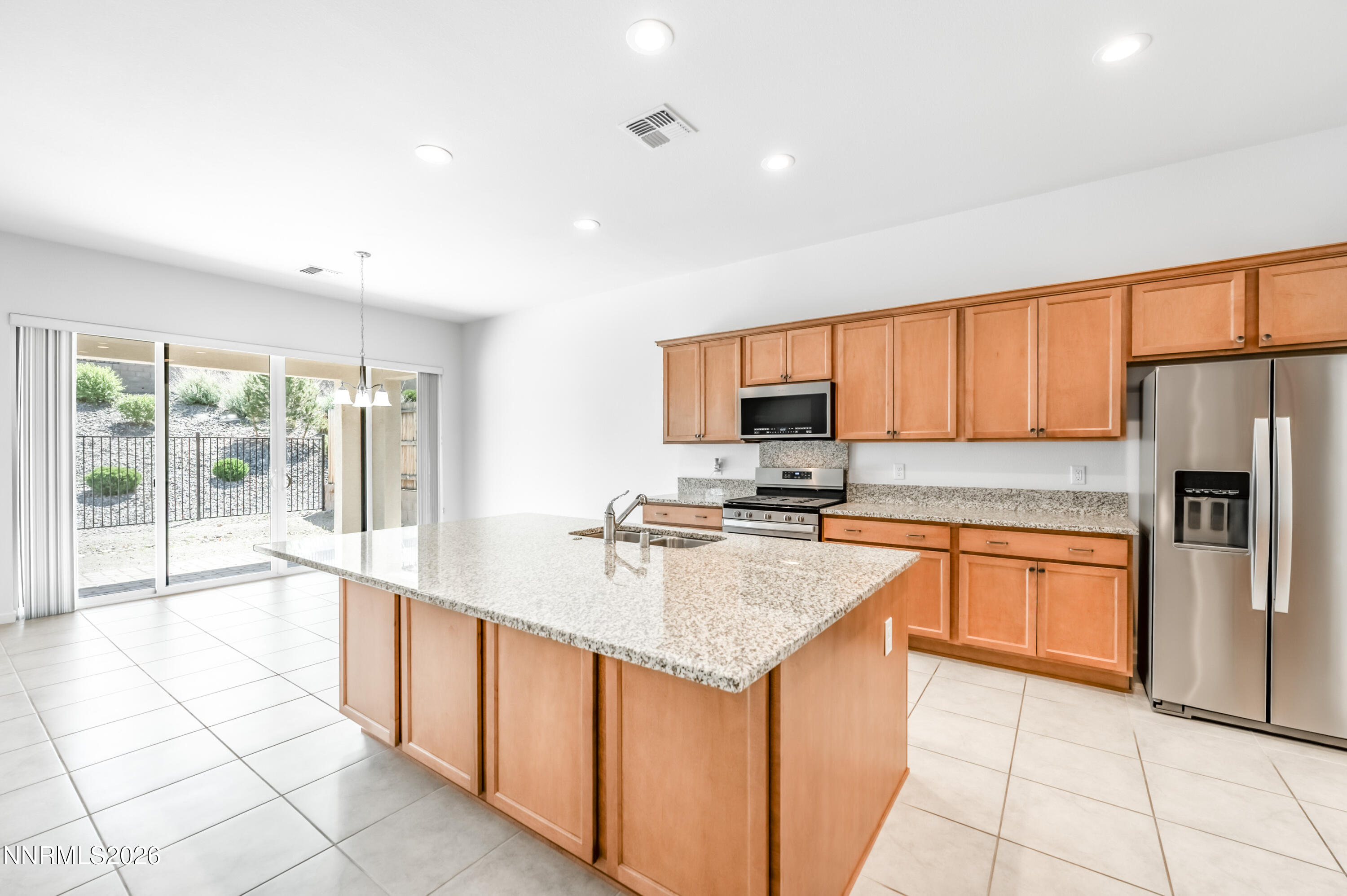 15024 Emerald Sunset Lane Reno, NV 89521 - Photo 27 of 73 a large kitchen with stainless steel appliances granite countertop a stove top oven a sink a counter top space and cabinets