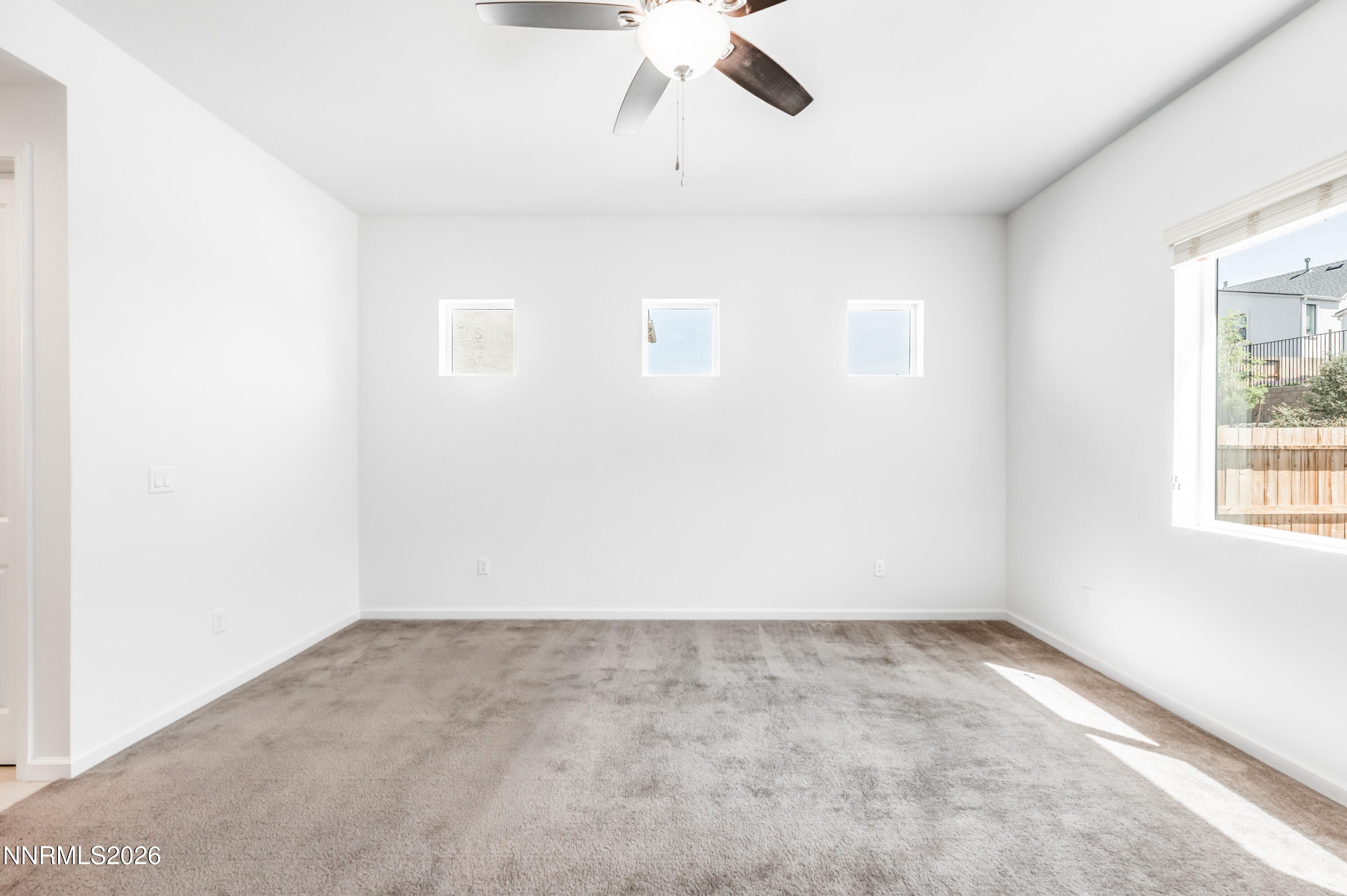 15024 Emerald Sunset Lane Reno, NV 89521 - Photo 33 of 73 an empty room with a window and a ceiling fan