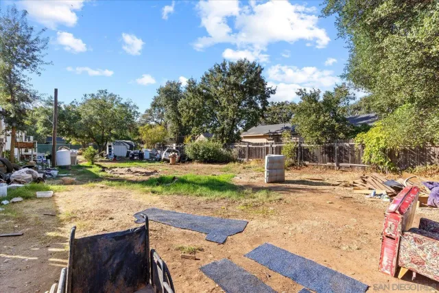 a house view with wooden fence and trees