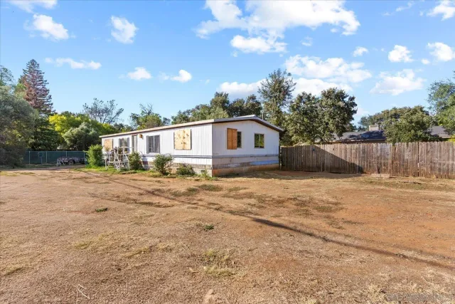 a view of house with backyard and trees