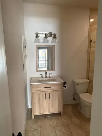 a bathroom with a toilet sink and mirror