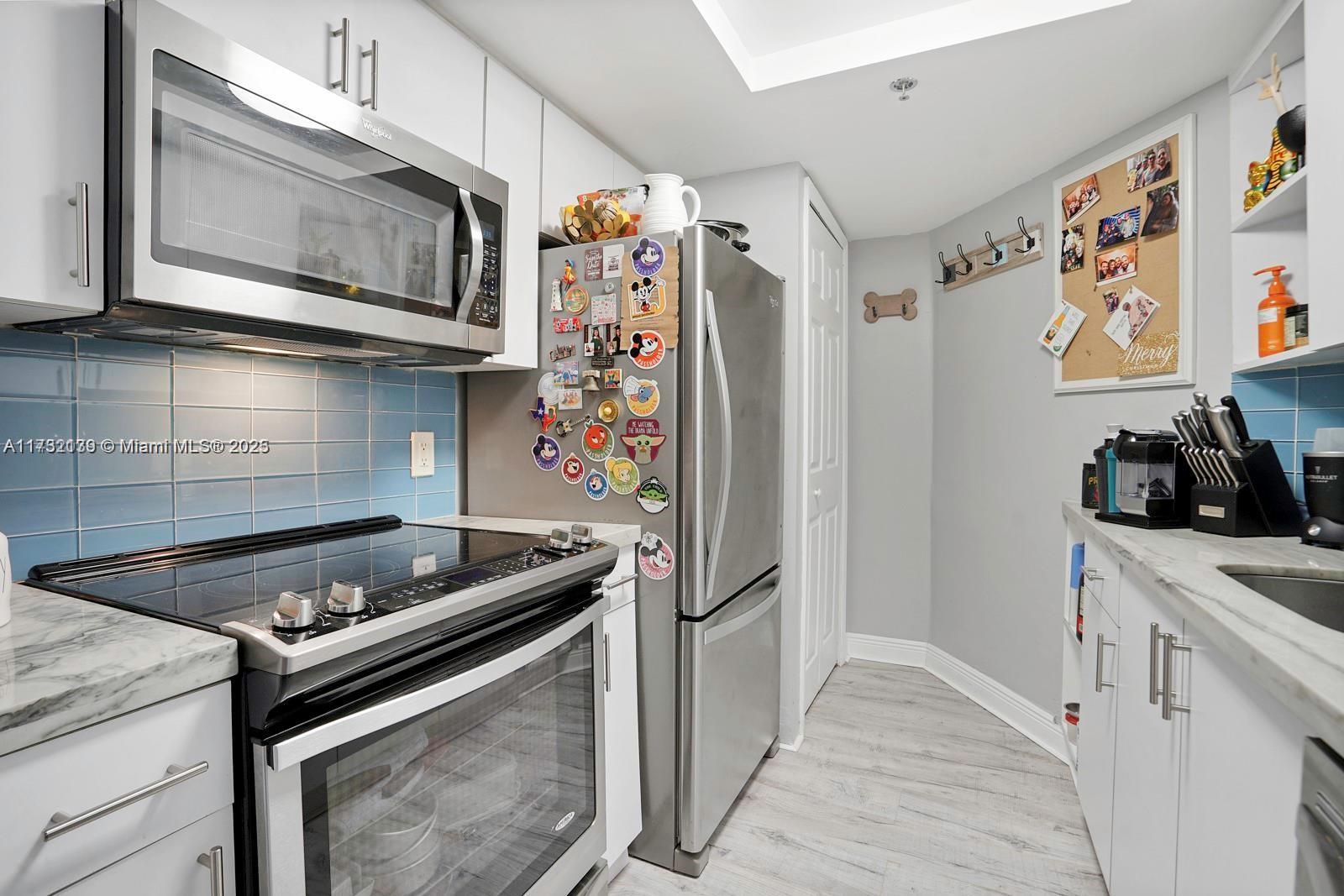 2475 Northwest 16th St Road, Unit 216 Miami, FL 33125 - Photo 11 of 16 a kitchen with stainless steel appliances granite countertop a stove and a refrigerator