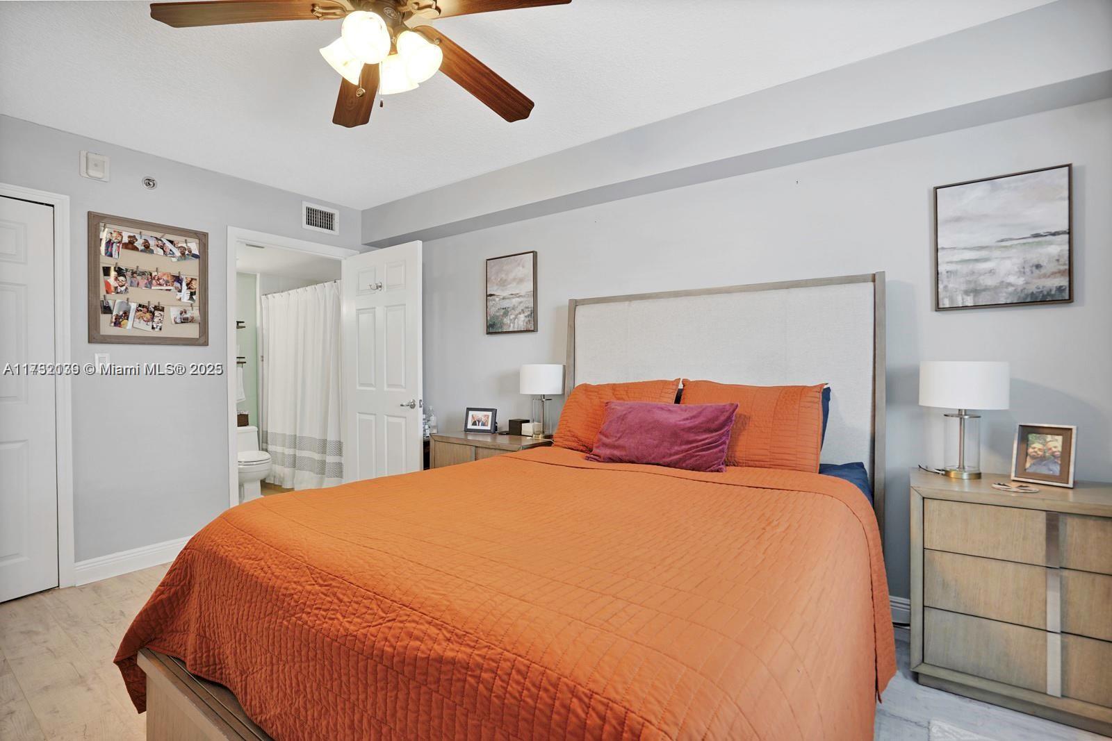 2475 Northwest 16th St Road, Unit 216 Miami, FL 33125 - Photo 12 of 16 a bedroom with a large bed and a chandelier